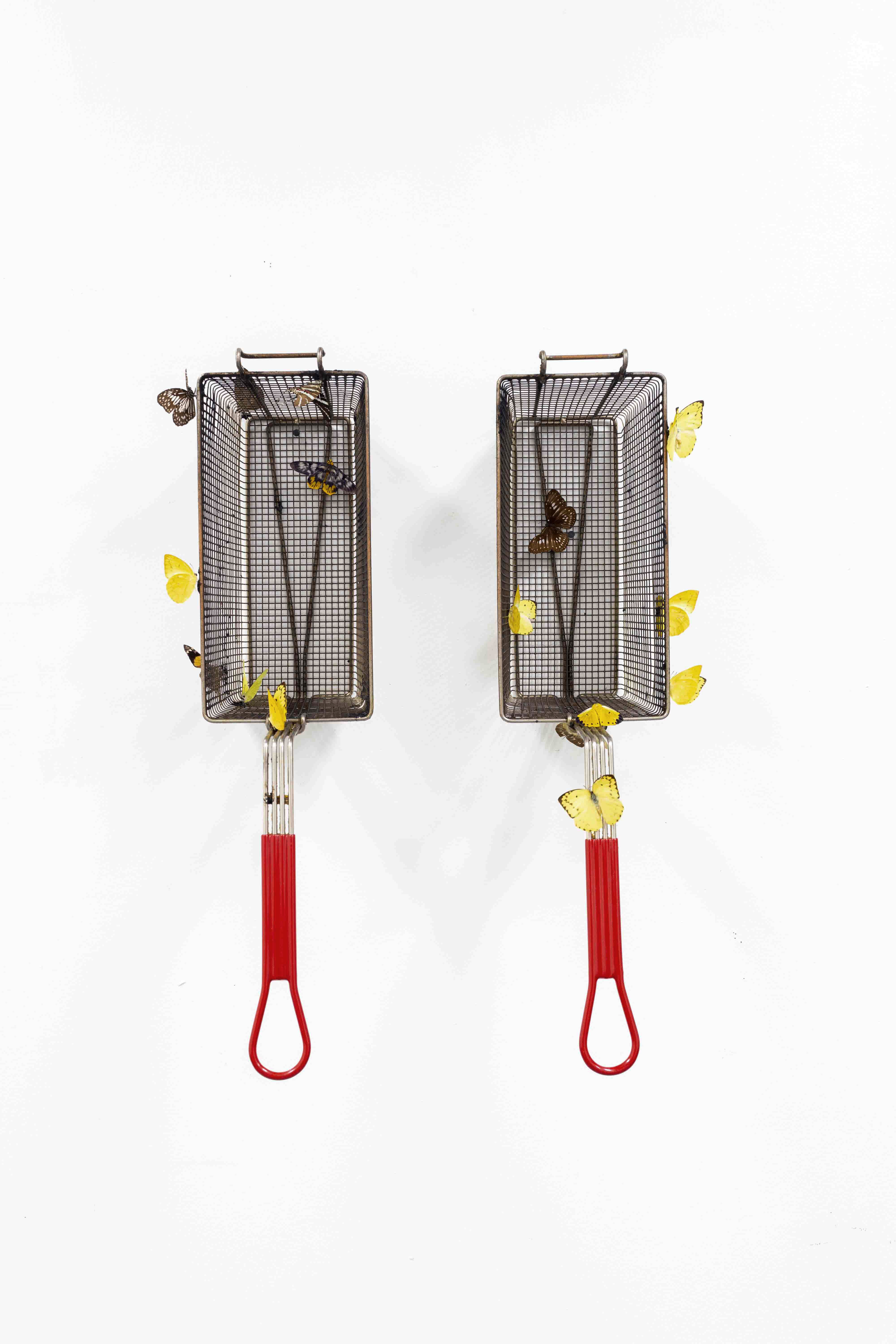 Any Meat on The Bone - A sculpture by Brian Dario, Featuring two fry baskets, with yellow and brown butterflies pinned to different parts of the fry baskets