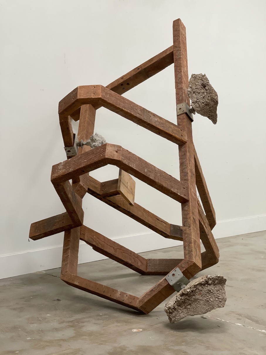Untitled - A sculpture by Brian Dario, Framing lumber, reconfigured into an off-kilter shape, with chiseled concrete footing chunks attatched via metal fastenings
